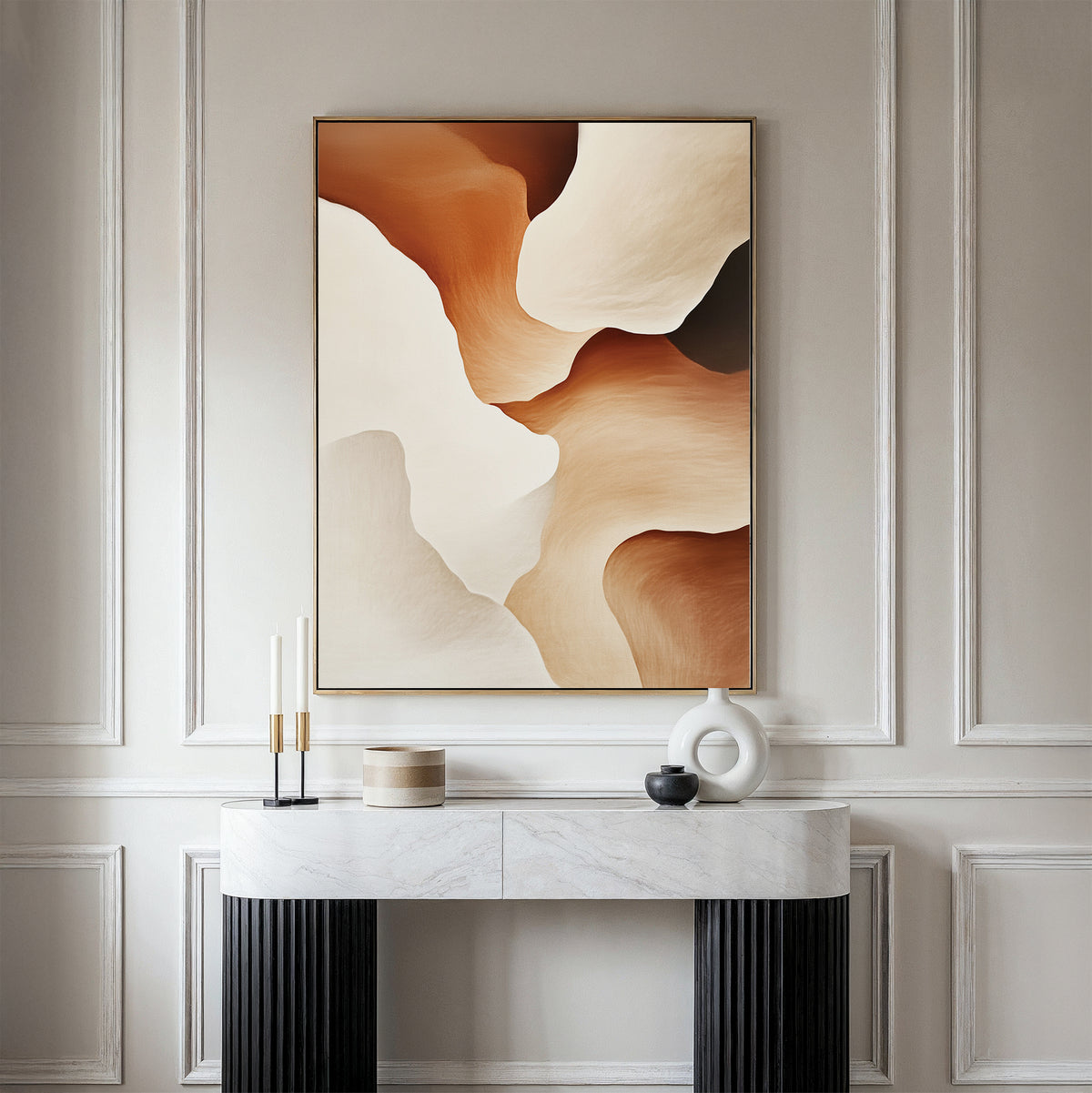 A minimalist console table with decorative objects sits against a paneled wall, topped by the Canyon Curves Canvas Art - Vertical in warm beige, brown, and cream—an ideal accent for modern living rooms.