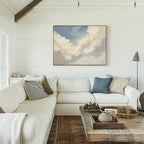 A bright, cozy living room with white shiplap walls, a large cream sectional sofa topped with pillows, the Celestial Embrace Canvas Art - Horizontal above, and a rustic coffee table featuring decorative trays and pottery.