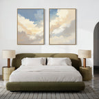 A modern bedroom featuring a green upholstered bed with white bedding, two gold nightstands and lamps, and the "Celestial Embrace - Set of 2" cloud canvas prints displayed above the bed on a white wall.