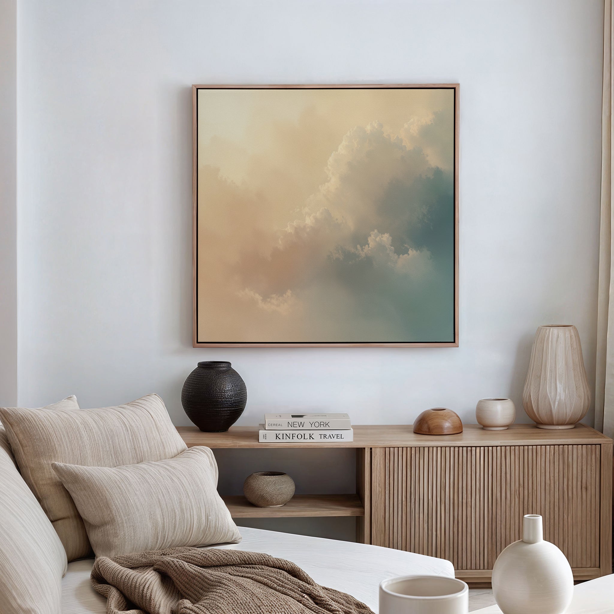 A modern, minimalist living room features a beige sofa, neutral cushions, wooden sideboard, decorative vases, stacked books, and the Celestial Veil Canvas Art - Square above. Soft champagne lighting completes this serene space.