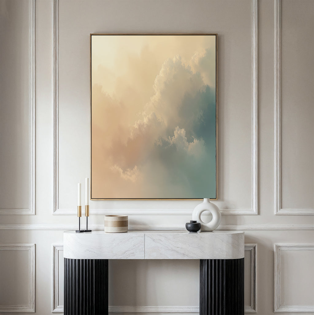 A minimalist interior showcases a marble console table, decorative objects, and the Celestial Veil Canvas Art - Vertical, featuring soft pastel clouds illuminated by champagne light, displayed on a beige paneled wall.
