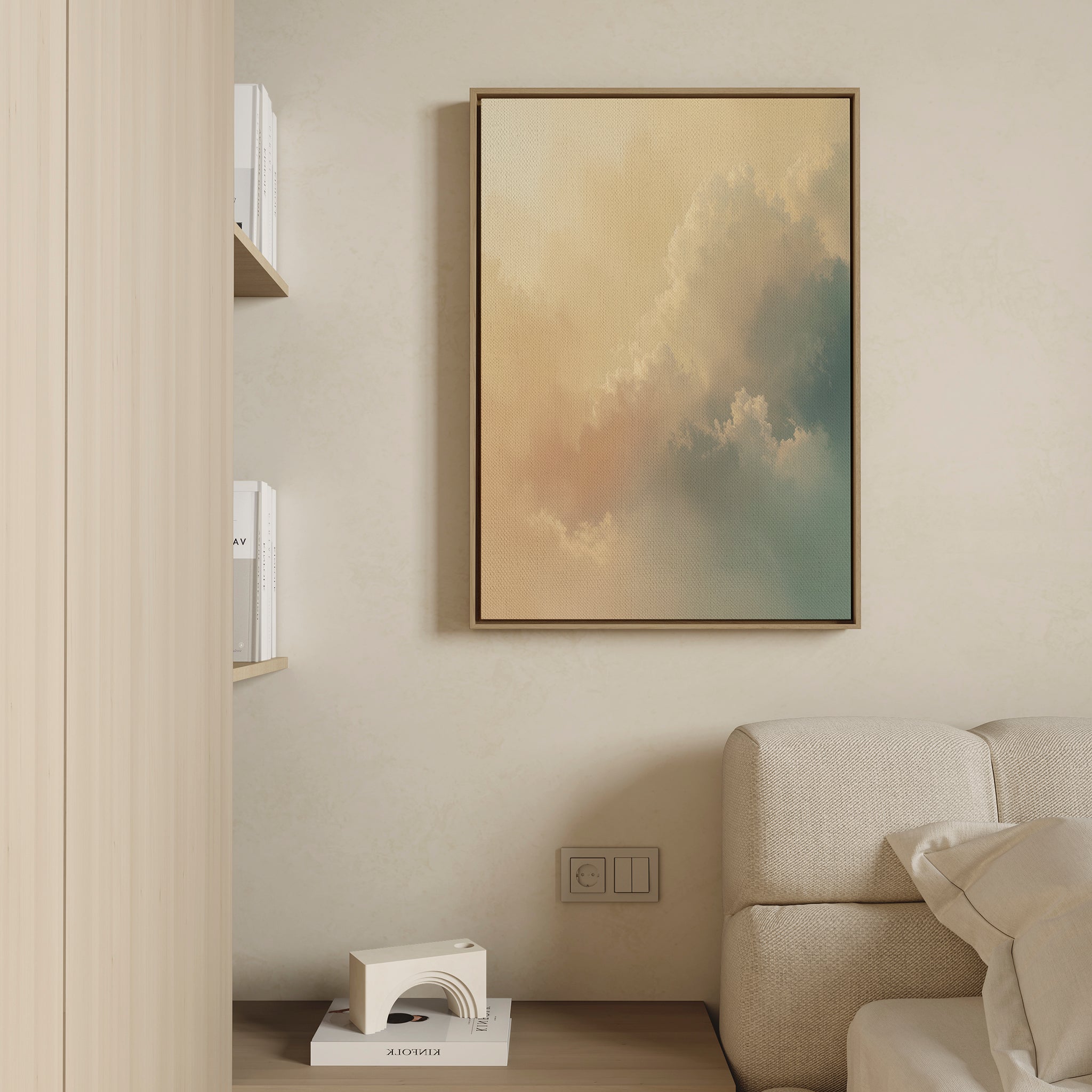 A modern living room with a beige wall, light sofa, champagne accents, wooden bookshelf with books, and the Celestial Veil Canvas Art - Vertical featuring pastel clouds hanging above the sofa.