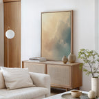 A minimal living room features a light wood sideboard, neutral ceramics, a small plant, a white armchair with a cushion, and the Celestial Veil Canvas Art - Vertical. Calm modern decor in soft neutrals is bathed in champagne light.