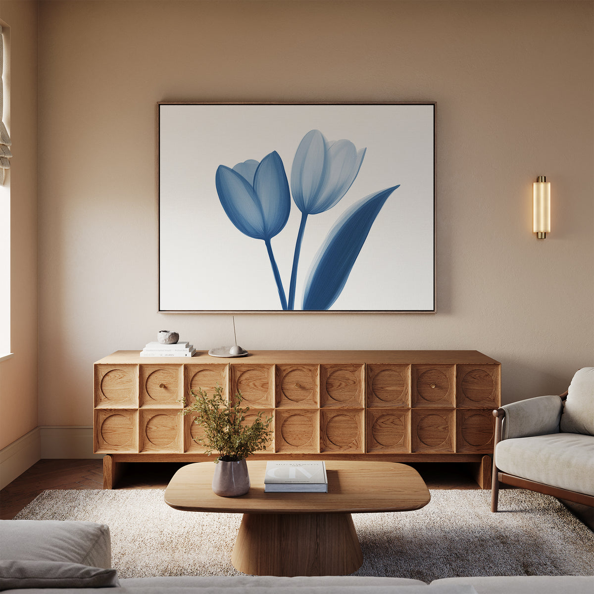 A cozy living room features a light sofa, wooden coffee table, and sideboard. Above hangs the Cerulean Tulips Canvas Art - Horizontal. A small plant and books on the table and sideboard complete the Nordic Park vibe.