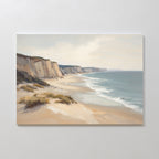 Chalk Shores Canvas Art - Horizontal: A canvas print of a coastal landscape with sandy beach, gentle waves, white cliffs under a cloudy sky, and sparse vegetation in the foreground. Ideal as coastal wall art or seaside decor.