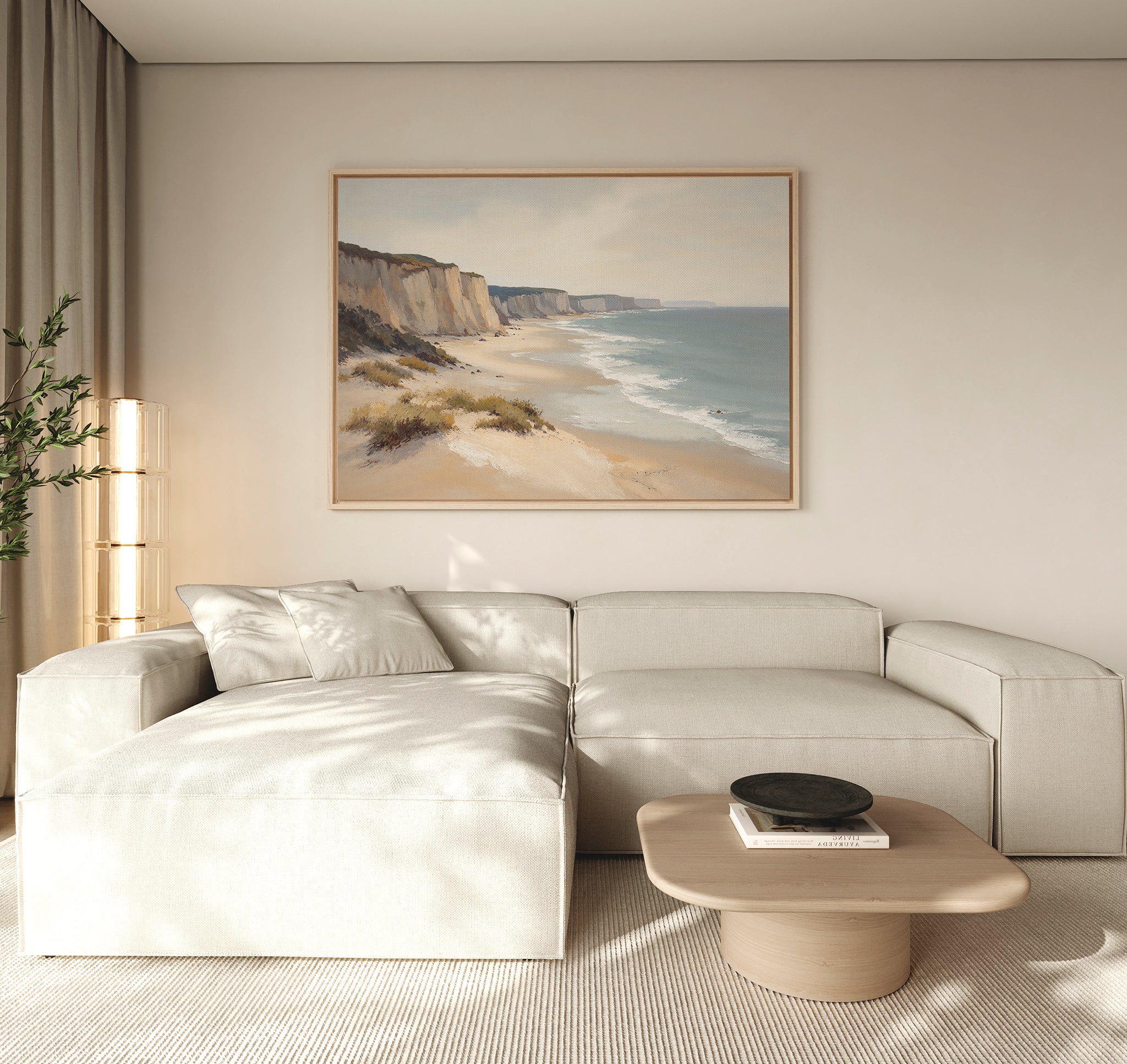 A modern living room with a light beige sectional sofa, a low wooden coffee table with a black bowl, a tall lamp, a potted plant, and striking coastal wall art—the Chalk Shores Canvas Art - Horizontal—displayed on the wall.