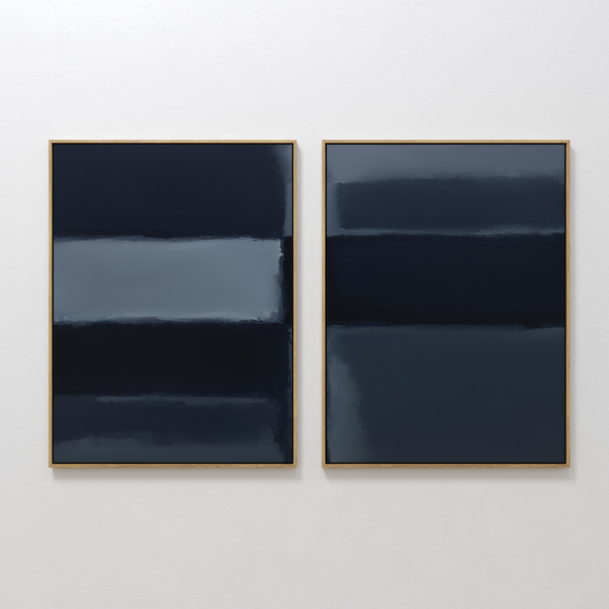 Charcoal Blocks - Set Of 2: Two modern abstract paintings with horizontal bands in dark blue, navy, and gray tones. Each features soft blended edges and a thin gold frame, beautifully displayed on a plain white wall.