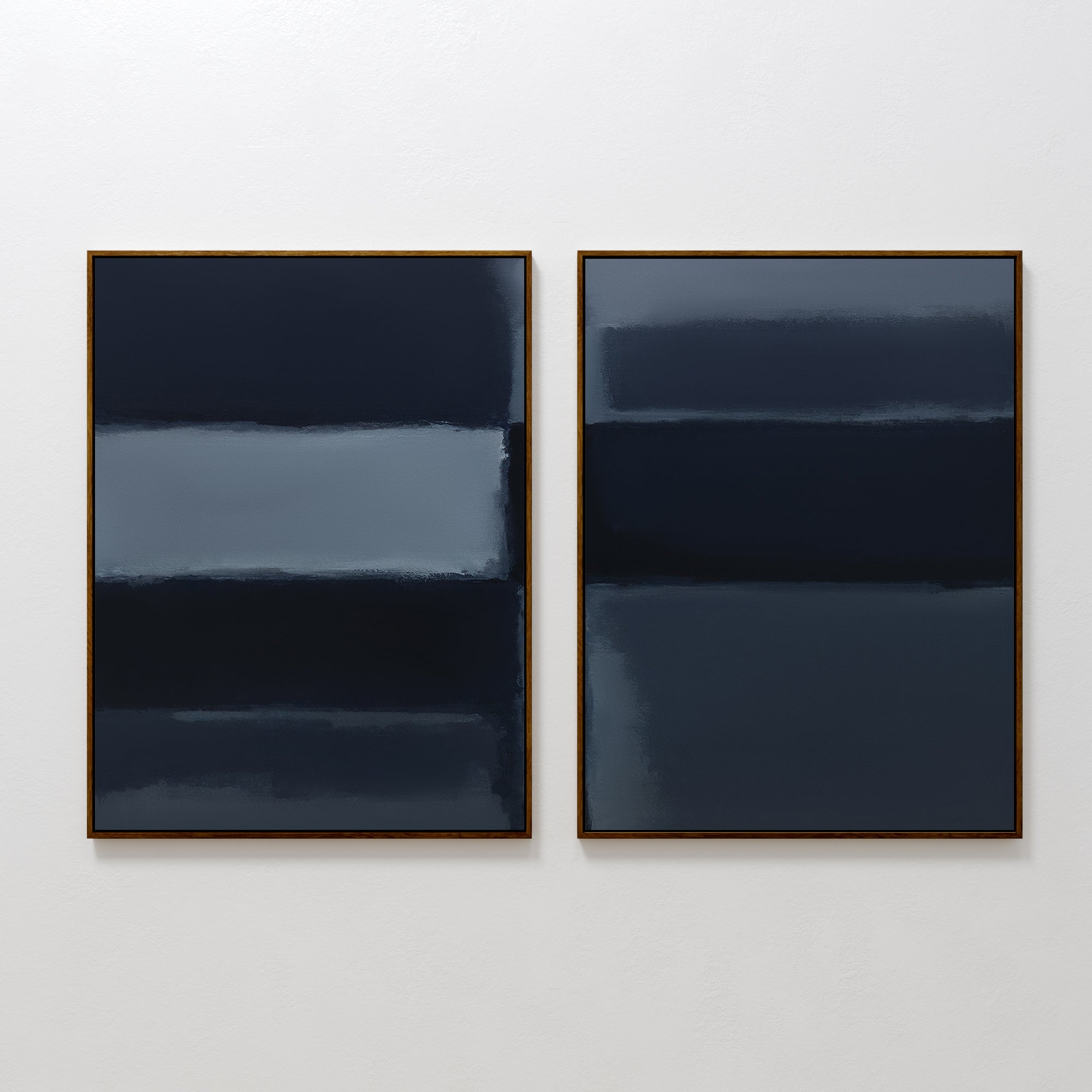 The Charcoal Blocks - Set Of 2 features abstract paintings with horizontal bands in dark blue, navy, and gray tones, each framed in slim gold and displayed side by side against a plain white wall.