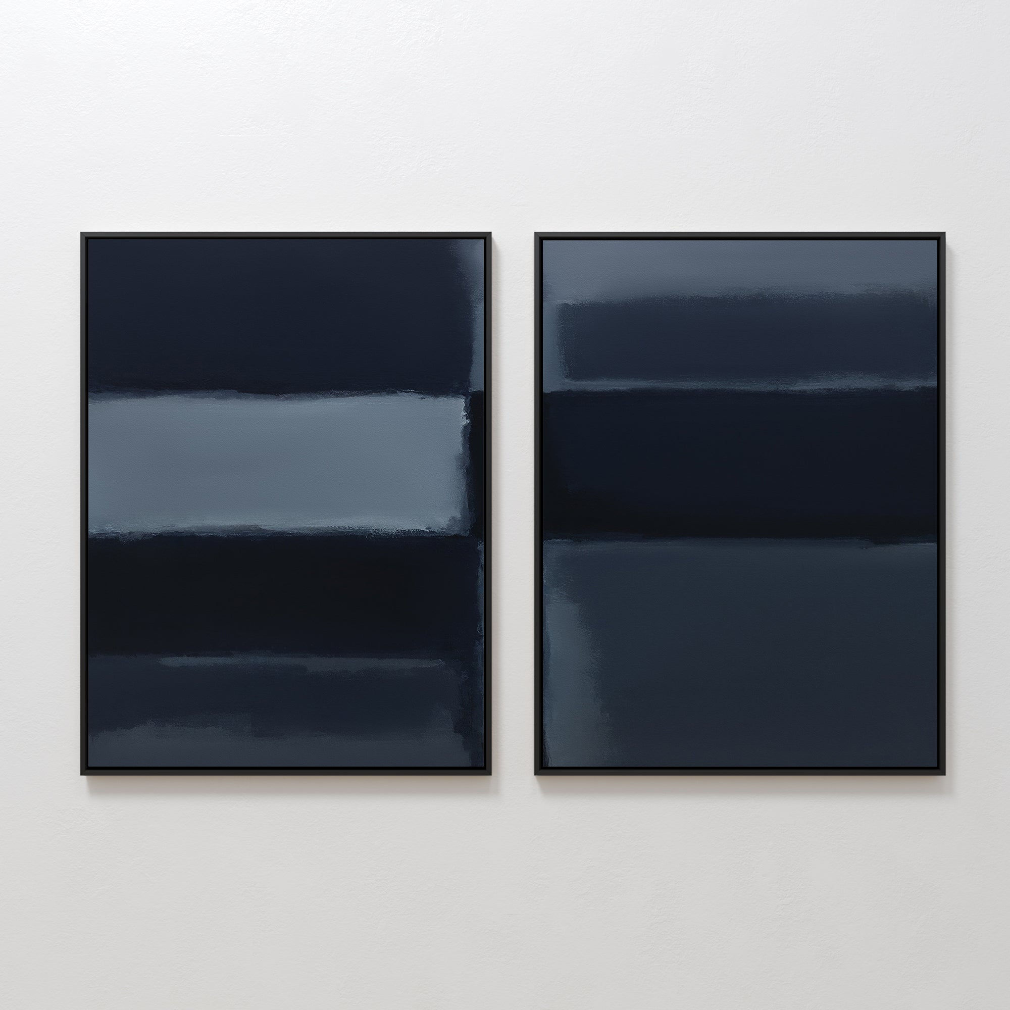 Charcoal Blocks - Set Of 2: Minimalist abstract prints feature horizontal bands of dark blue and gray with soft, blended edges. Displayed in sleek black frames, these modern pieces create a moody, atmospheric effect on any white wall.