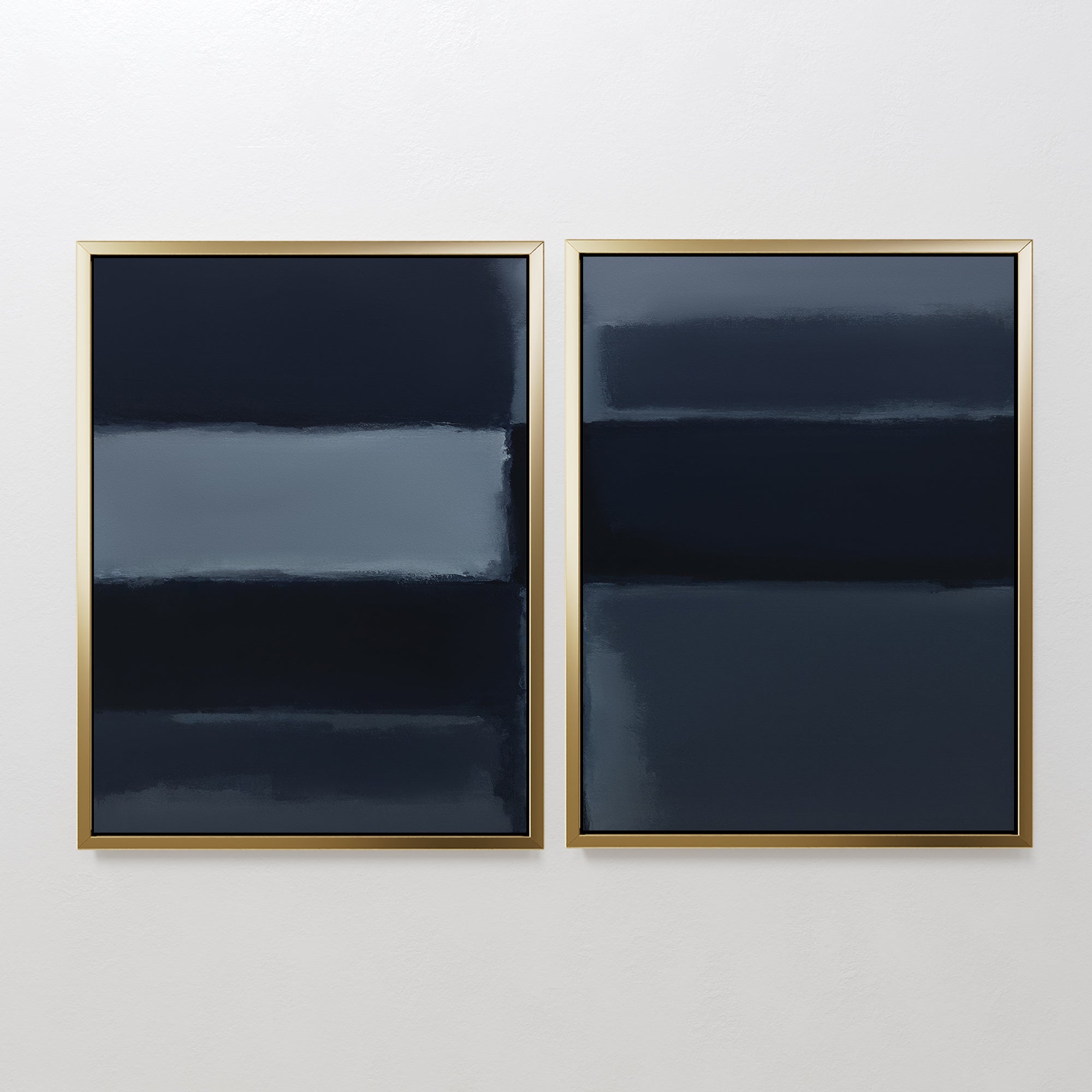 The Charcoal Blocks - Set Of 2 features minimalist prints framed in gold, each showcasing horizontal bands of dark blue, black, and gray for a moody modern look that pops against a white wall.