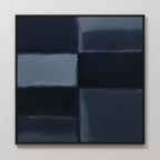 Charcoal Blocks Canvas Art - Square: A minimalist abstract painting with blurred dark blue and gray charcoal rectangles, divided by soft lines. Set in a thin black frame against a white wall—ideal for modern decor.