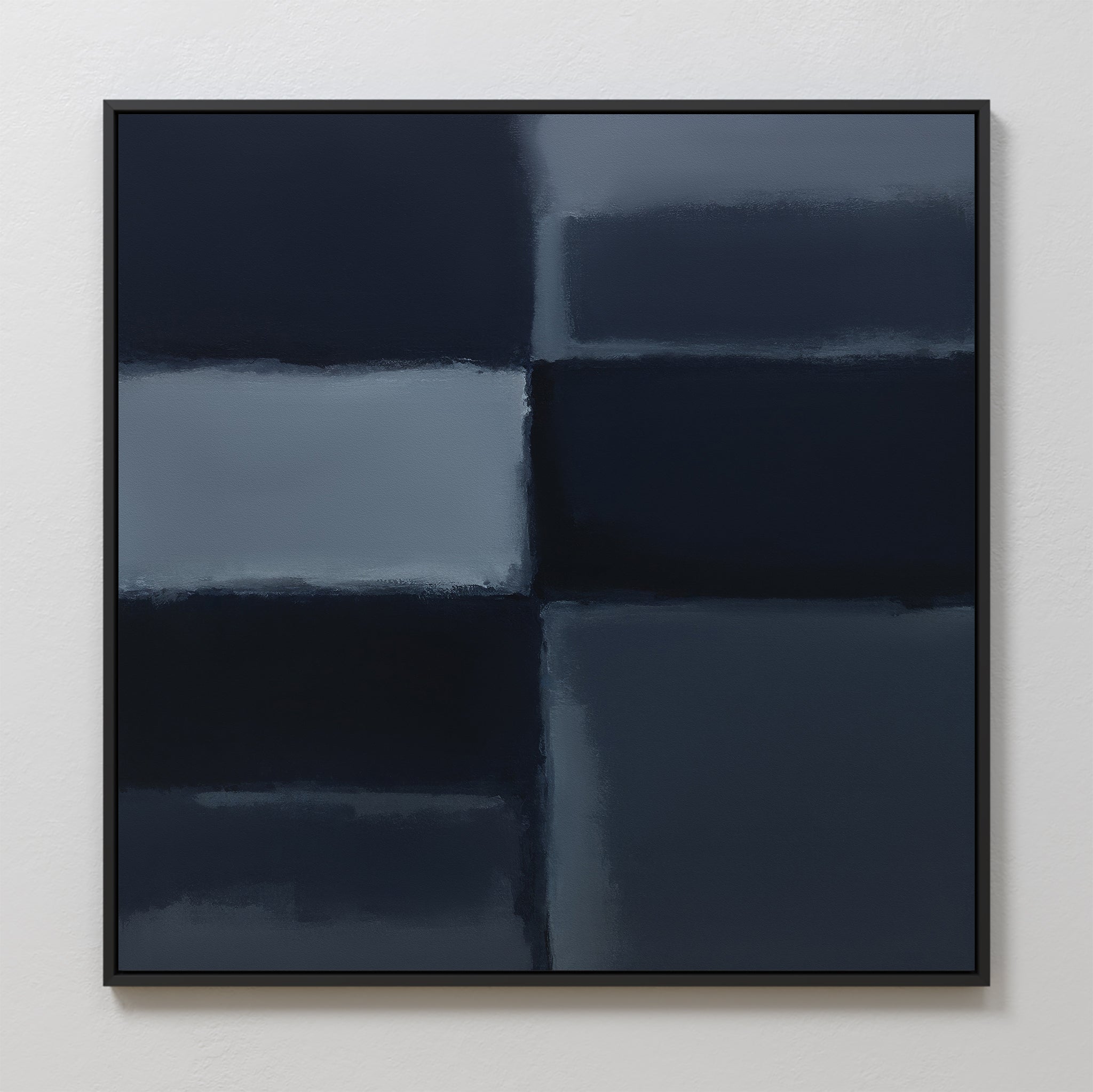 Charcoal Blocks Canvas Art - Square: A minimalist abstract painting with blurred dark blue and gray charcoal rectangles, divided by soft lines. Set in a thin black frame against a white wall—ideal for modern decor.