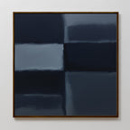Charcoal Blocks Canvas Art - Square features four large, blurred rectangles in dark blue and navy, divided by soft lines. Framed in brown and displayed on a plain white wall, it’s ideal for modern home decor and minimalist spaces.