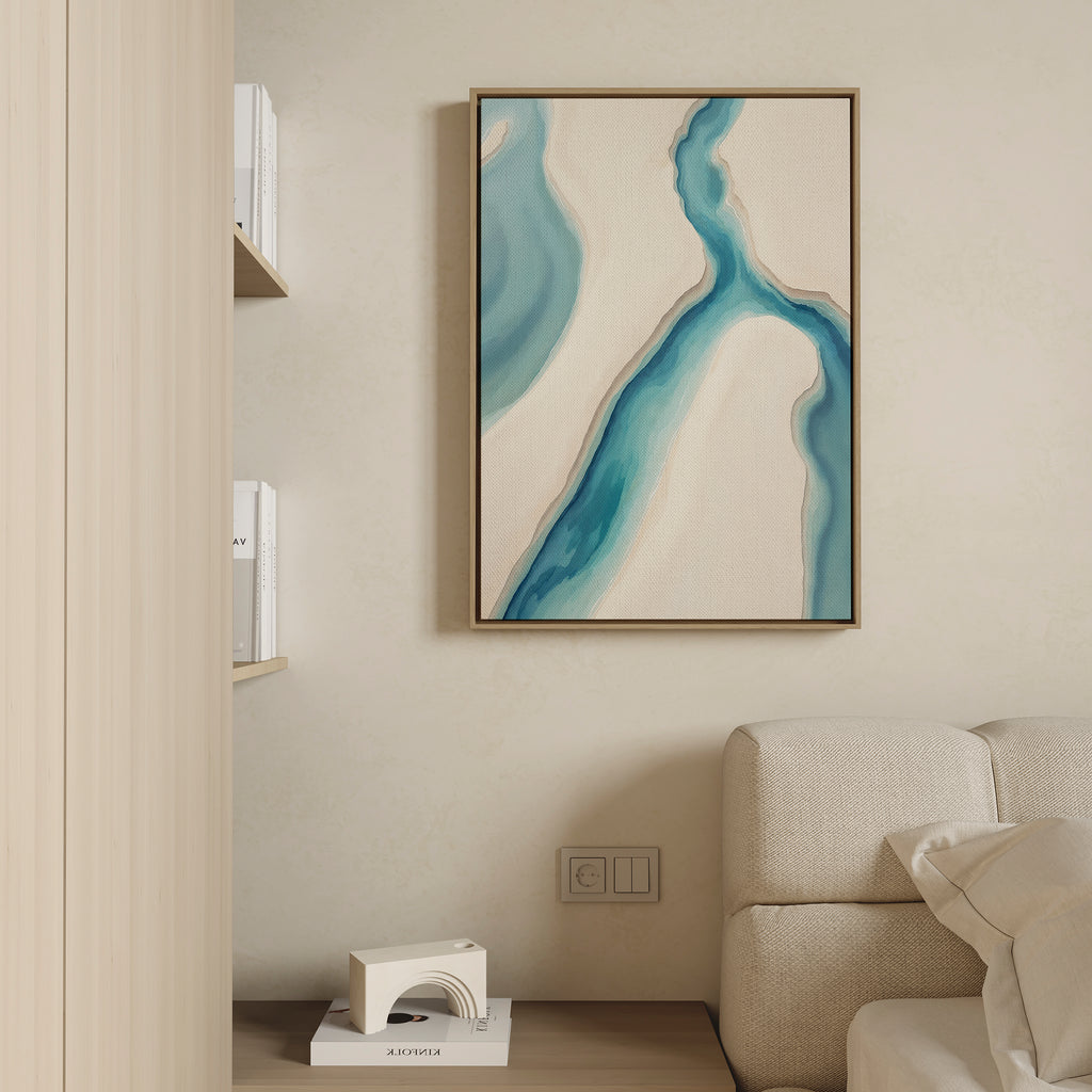 A modern living room corner with a beige sofa, built-in shelves, and serene decor featuring the Coastal Dreams Canvas Art - Vertical, an abstract print with blue and beige shapes hanging on a light wall above a small white sculpture.