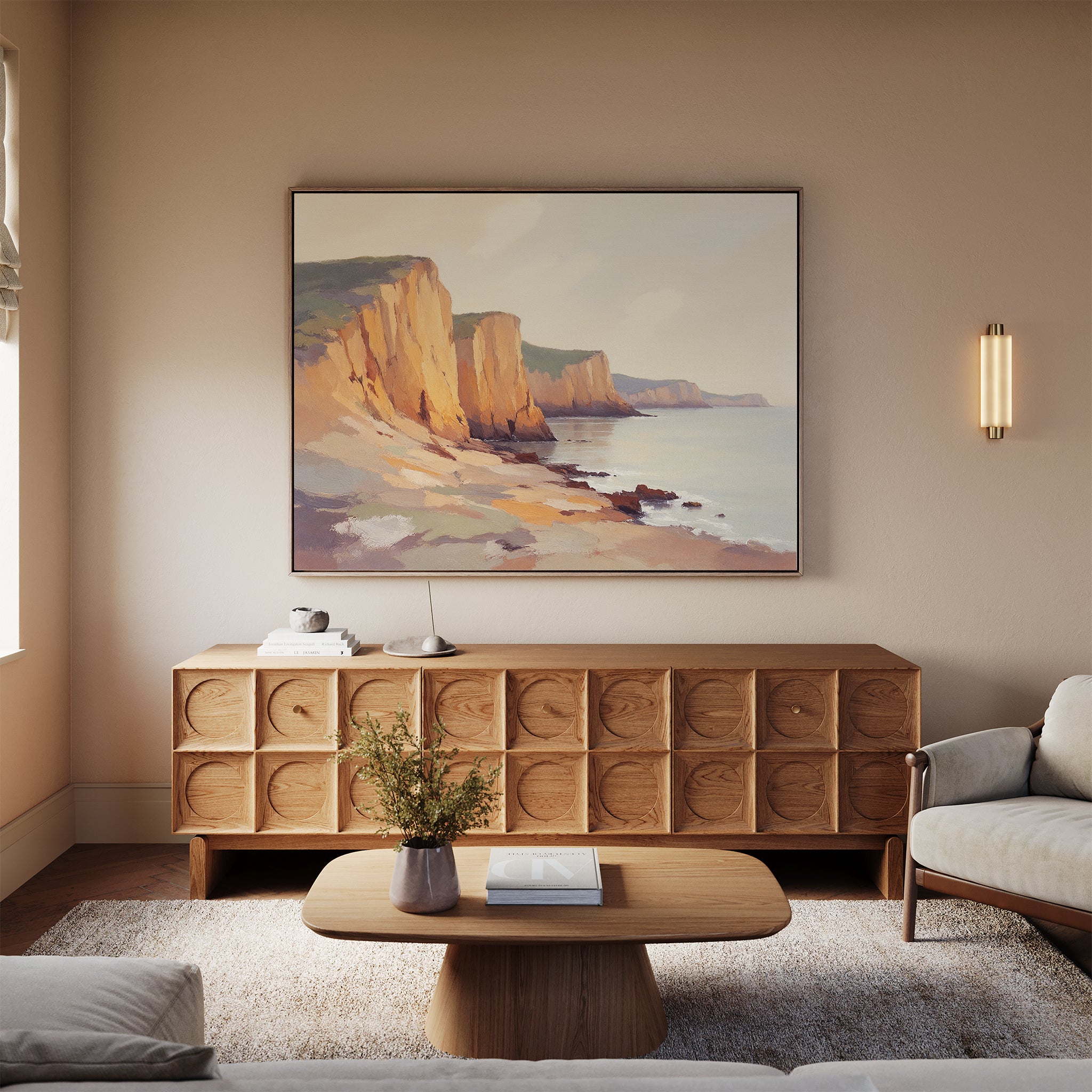 A cozy living room with neutral tones, a wooden sideboard, coffee table with a vase, sofa, soft natural light from a window, and the Coastal Grandeur Canvas Art - Horizontal as striking seaside wall decor.