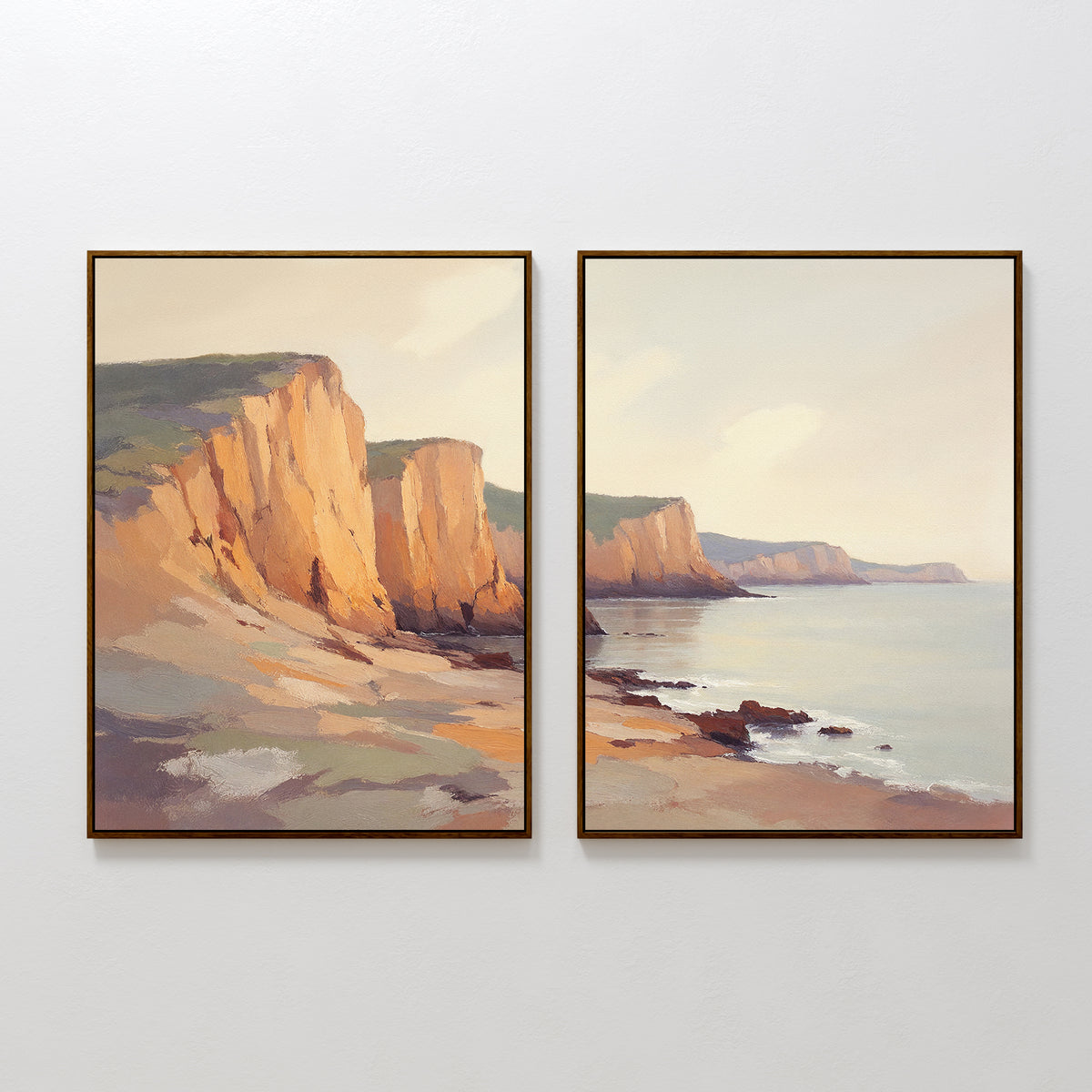 Coastal Grandeur - Set of 2 features two framed canvas prints with sunlit cliffs and a rocky shoreline in soft pastel tones, capturing a serene coastal vibe—ideal for adding tranquility to any space.