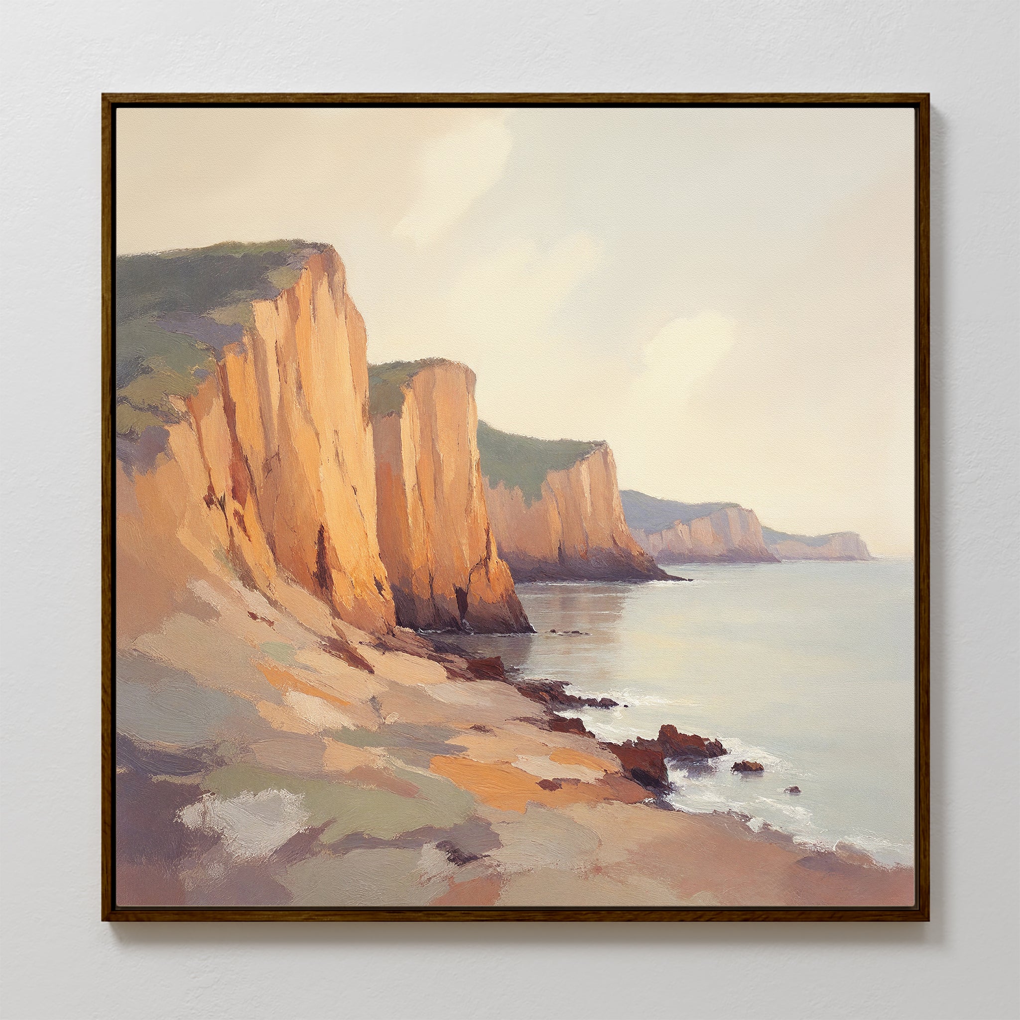 The Coastal Grandeur Canvas Art - Square features sunlit seaside cliffs along a serene coast, with warm tones illuminating the rocky landscape and gentle waves under a partly cloudy sky.