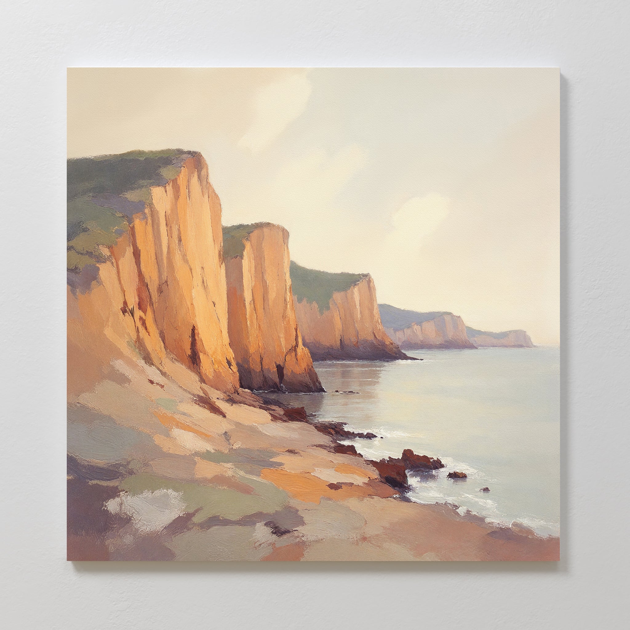 Experience tranquility with the Coastal Grandeur Canvas Art - Square: sunlit seaside cliffs above a calm sea, rocky shorelines, and pastel skies. This coastal wall art adds warmth and beauty to any space.