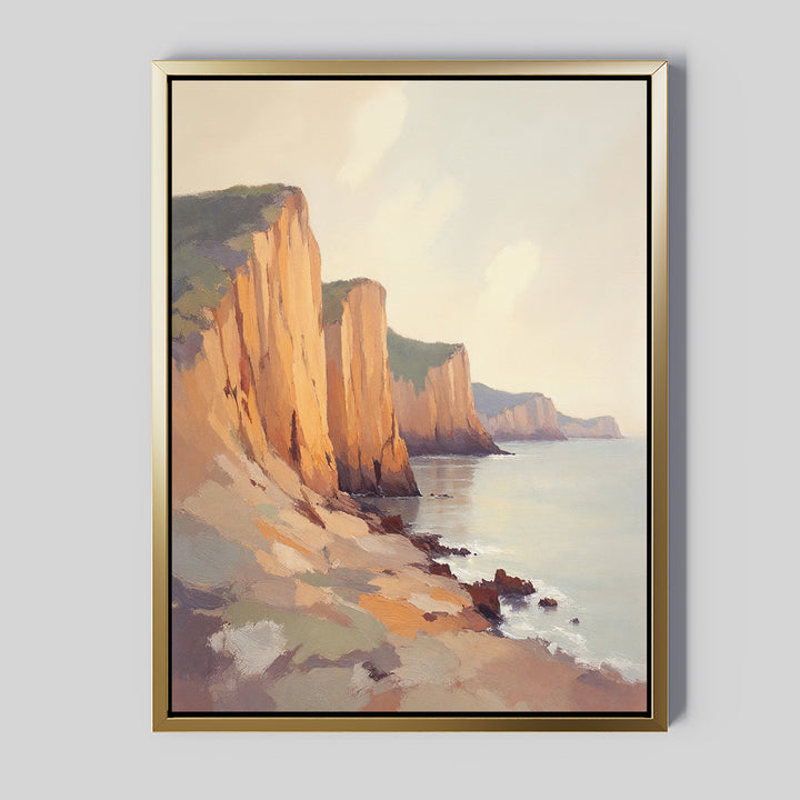 Coastal Grandeur Canvas Art - Vertical features sunlit seaside cliffs above a calm sea, rocky shoreline in the foreground, and soft hazy clouds. Warm tones create a serene, peaceful coastal wall art for your space.