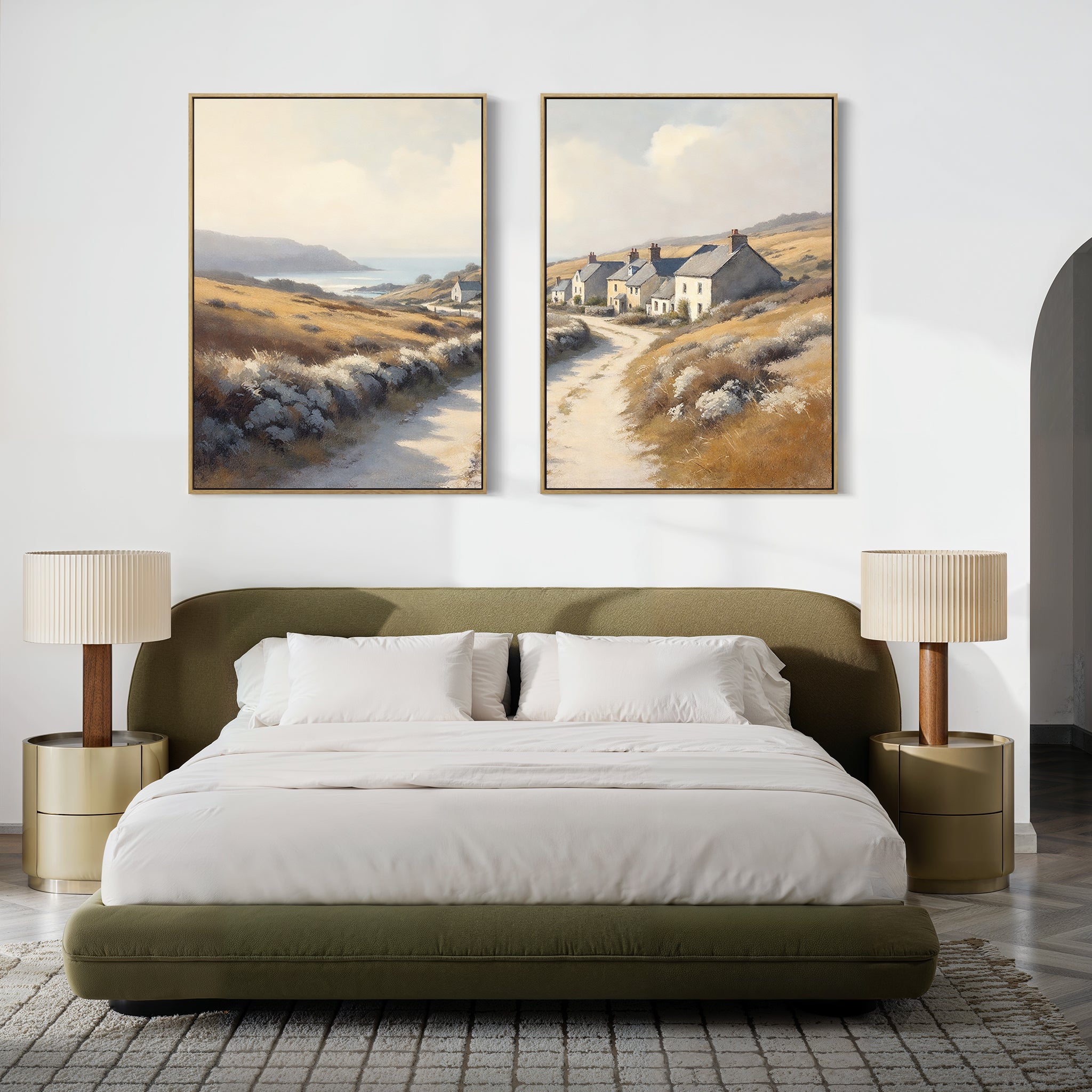 A modern bedroom with a low olive-green bed, white bedding, two round beige nightstands with matching lamps, and the "Coastal Haven - Set of 2" large landscape canvas prints of a coastal village hanging above the bed.