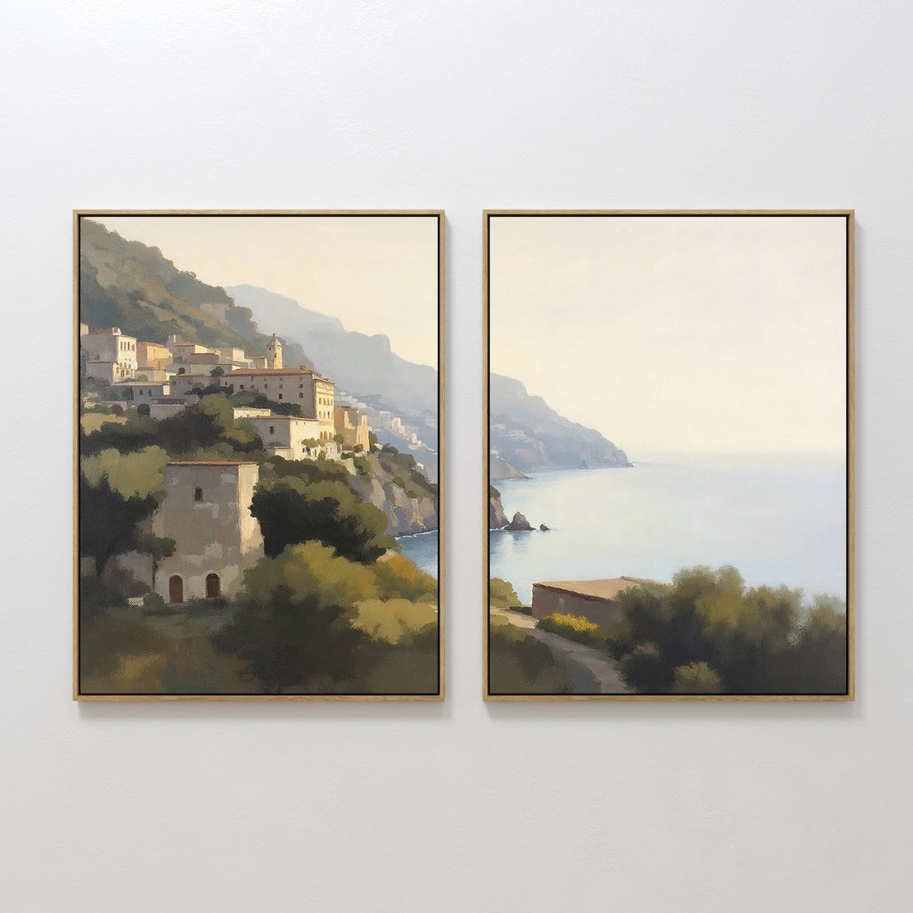 Italian Reverie - Set of 2 features framed paintings of a coastal landscape with hillside buildings and a calm sea in soft, muted colors—ideal coastal wall art for elegant home decor.
