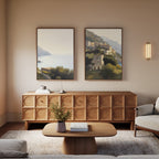 A modern living room with a wooden sideboard, light wood coffee table, beige sofa, and the Italian Reverie - Set of 2 wall art above the sideboard. A wall sconce and stylish decor accents make the space cozy and inviting.