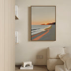 The Coastal Reverie Canvas Art - Vertical hangs on a beige wall above a light sofa, its orange and blue hues bringing calm. Nearby shelves with books and a white geometric decor piece complete the tranquil home vibe.