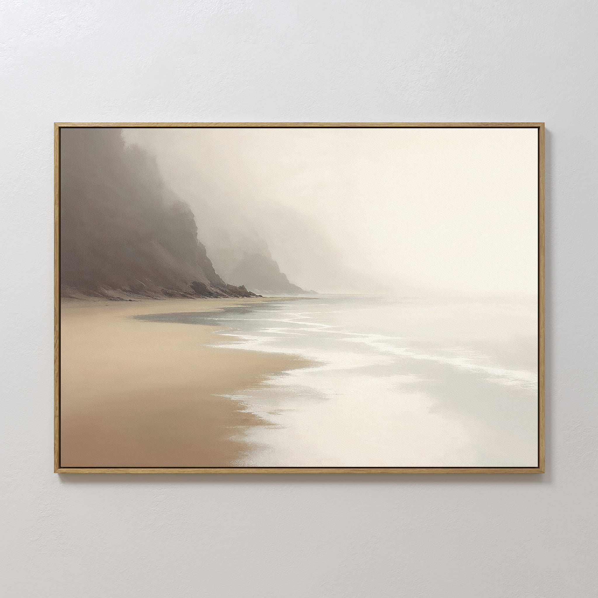 The Coastal Silence Canvas Art - Horizontal features a serene, misty beach with gentle waves and distant cliffs, perfect for muted coastal decor. Its soft tones look stunning when hung on a light-colored wall.