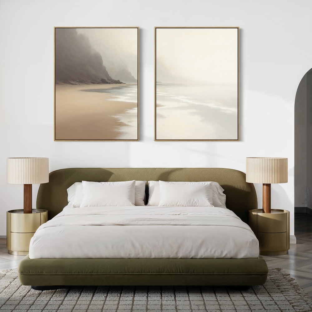 A modern bedroom with an olive-green bed, white bedding, gold nightstands, and beige lamps features neutral tones and minimal decor. Above the bed, the "Coastal Silence - Set of 2" canvas prints add a serene touch.