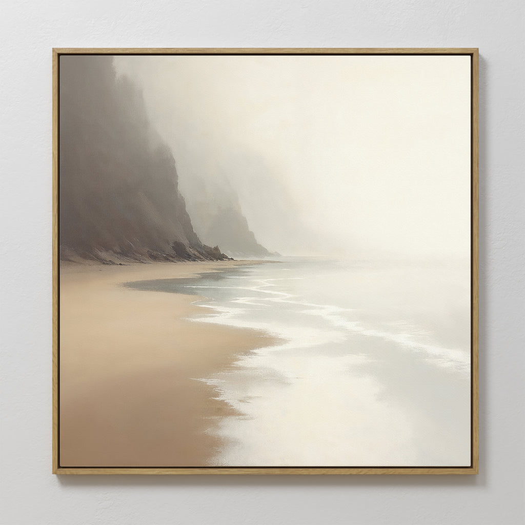 The Coastal Silence Canvas Art - Square features a misty beach with gentle waves, wet sand, and cliffs on the left. Its soft light and natural palette create a peaceful, serene atmosphere for any space.