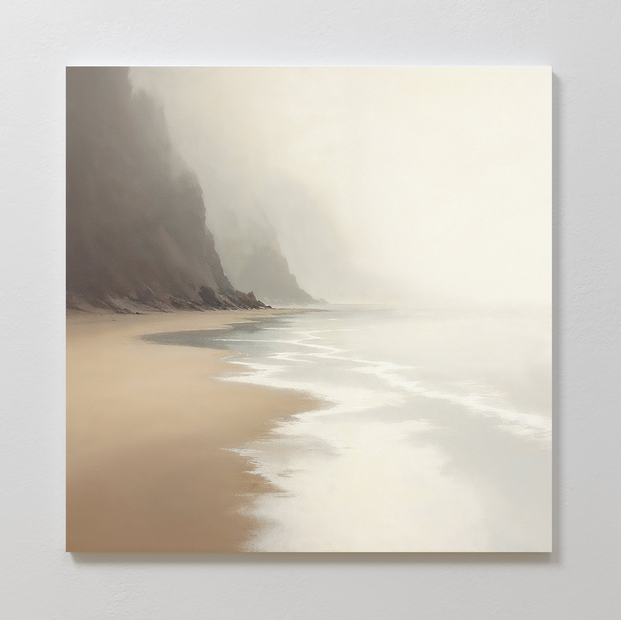 The Coastal Silence Canvas Art - Square features a soft seascape with gentle waves on a sandy shore, misty cliffs in the background, and a serene Nordic Park feel in natural tones of beige, gray, and white.