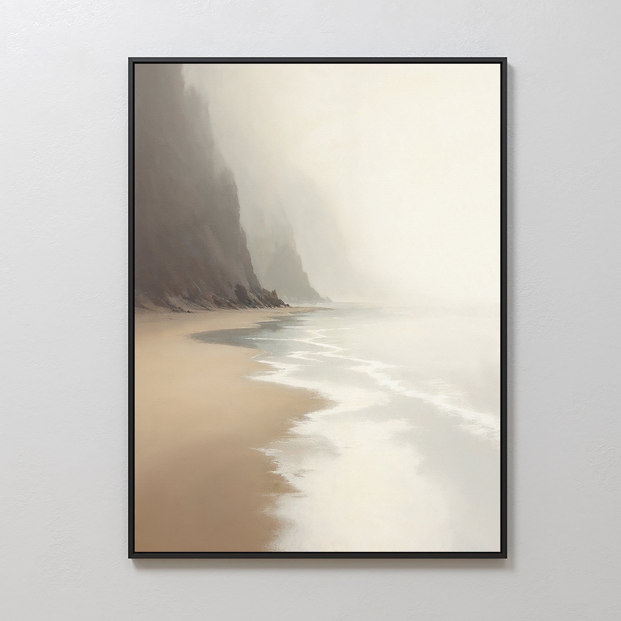 The Coastal Silence Canvas Art - Vertical features a serene beach scene with gentle waves, sandy shore, and misty cliffs under a foggy sky, elegantly framed and displayed on a plain white wall.