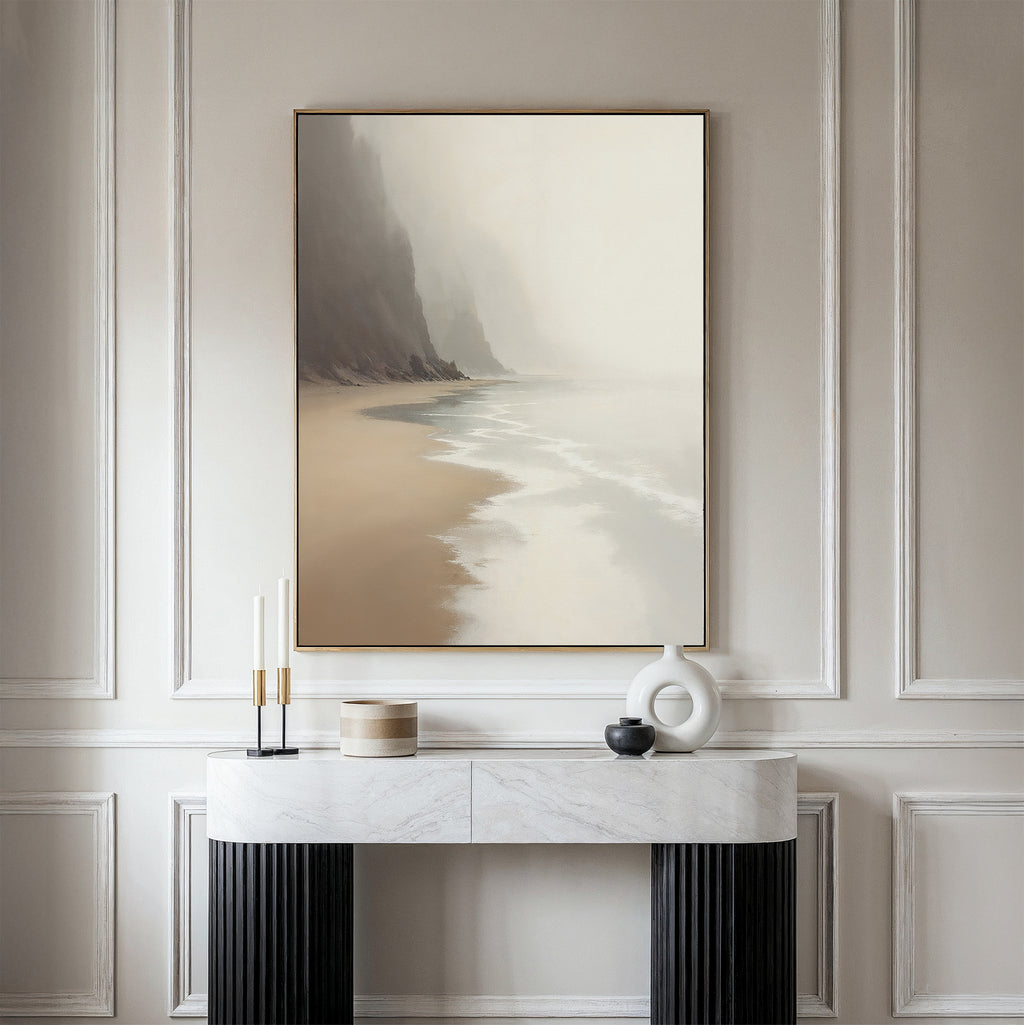 The "Coastal Silence Canvas Art - Vertical" hangs on a beige wall above a marble console table decorated with minimalist items like candles, a round box, and a white abstract vase.