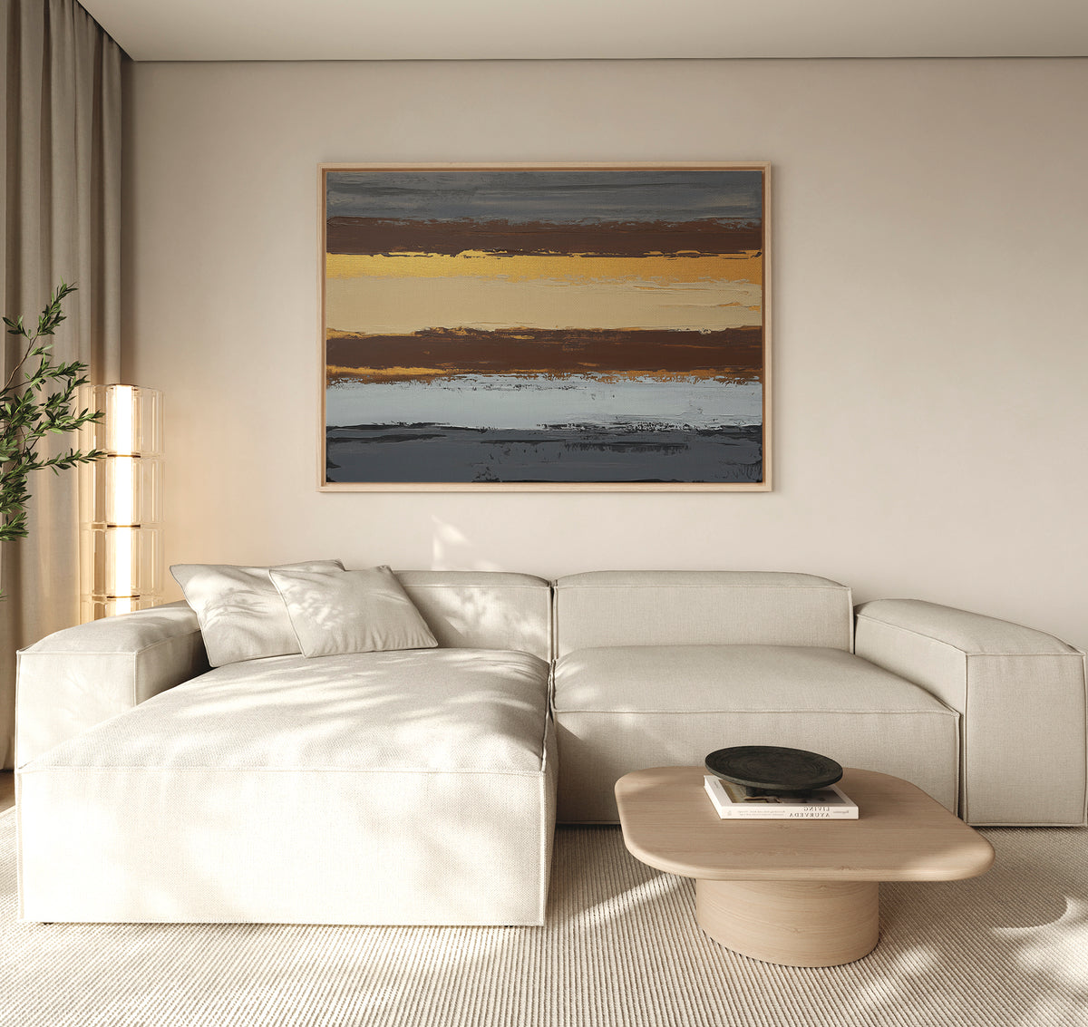 A modern living room with a beige sectional, light wood coffee table, and the Coastal Strata Canvas Art - Horizontal featuring earthy stripes. A black dish rests on the table as natural light from the left enhances the earthy sophistication.
