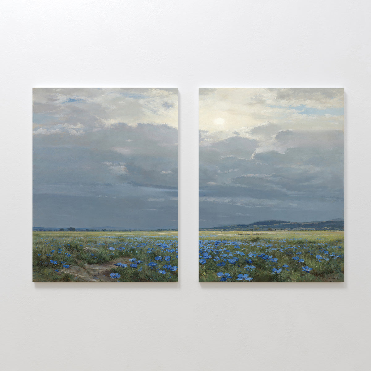 Cornflower Fields - Set of 2: This pair of canvas paintings showcases a peaceful pastoral scene with cornflower fields under a cloudy sky, rolling distant hills, and gentle sunlight filtering through the clouds.