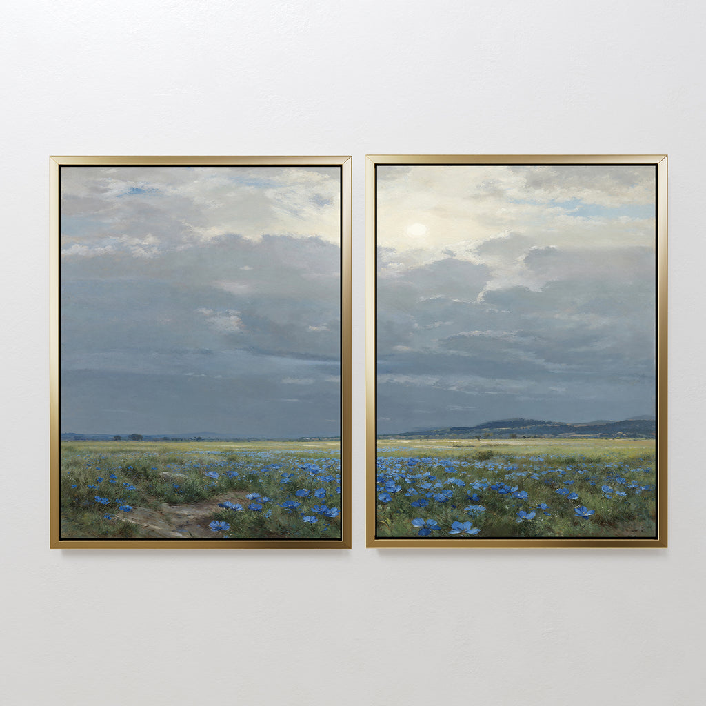 The Cornflower Fields - Set of 2 features framed canvas prints showing a pastoral landscape with wide cornflower fields, distant hills, and soft sunlight filtering through clouds against a white wall.