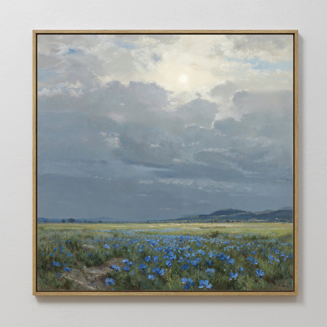 Add countryside charm to your space with "Cornflower Fields Canvas Art - Square," featuring blue wildflowers under a cloudy sky and sunlight, distant hills, and a peaceful muted palette—ideal for serene wall decor.