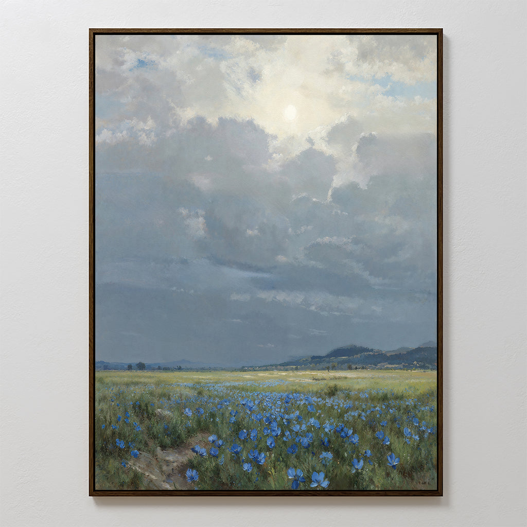 The Cornflower Fields Canvas Art - Vertical showcases a pastoral landscape of blue wildflowers stretching across a sunlit field beneath a cloudy sky, with distant hills visible on the horizon.