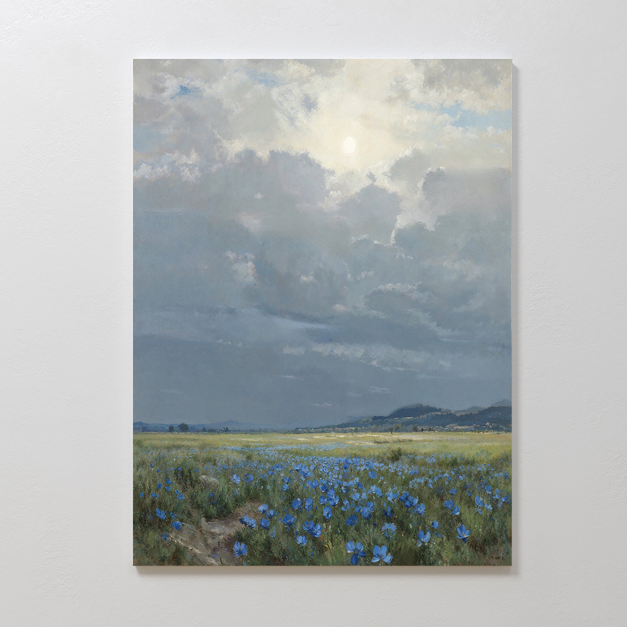 The Cornflower Fields Canvas Art - Vertical depicts a tranquil pastoral landscape with cornflower fields beneath a cloudy sky, sunlight streaming through, and distant hills on the horizon—perfect for bringing nature’s beauty to your space.