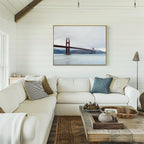 A bright, cozy living room with a white sectional sofa, assorted pillows, a rustic wooden coffee table, and the Crimson Passage Canvas Art - Horizontal on a white shiplap wall exudes coastal elegance.