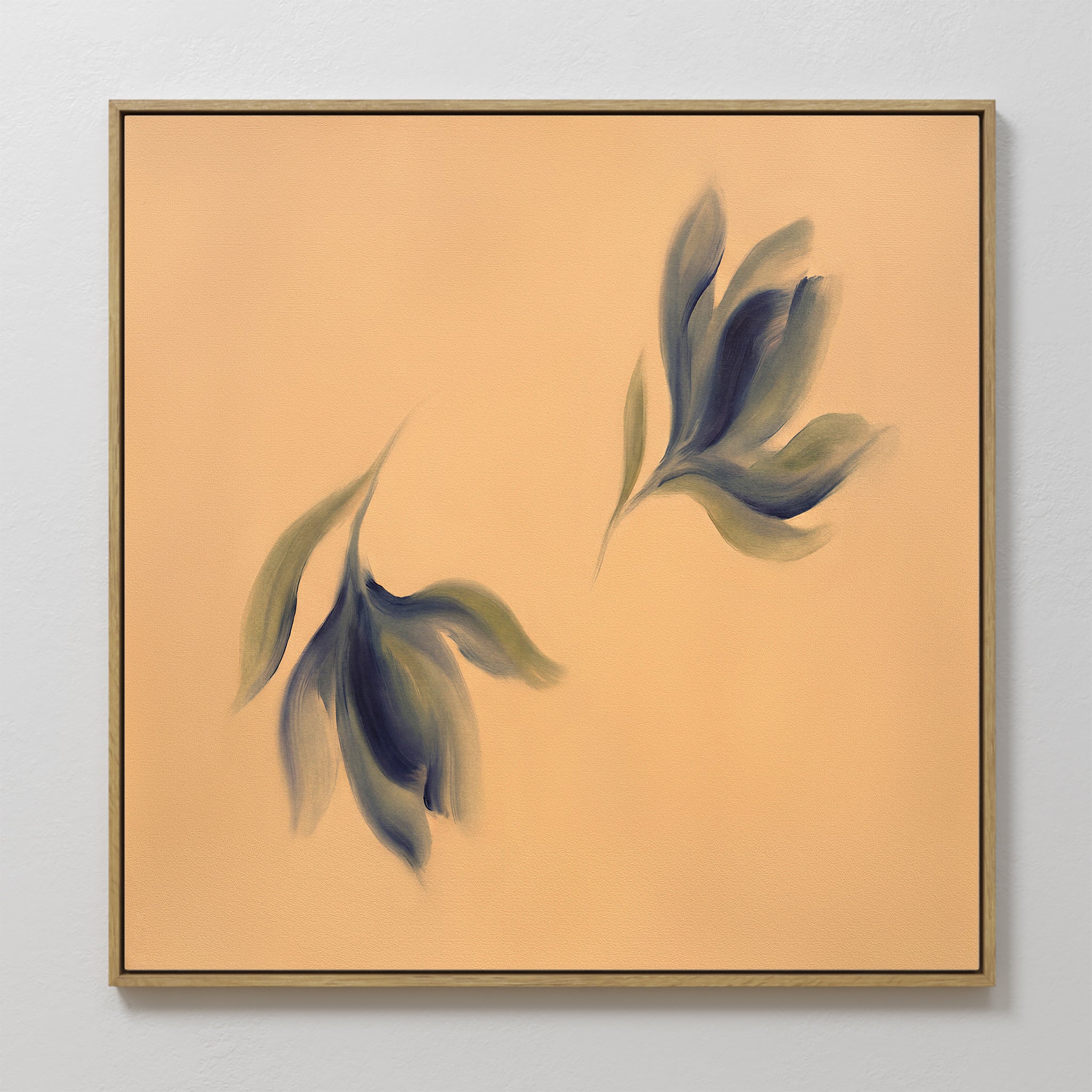 The Dancing Leaves Canvas Art - Square features two abstract, blurred leaf forms in green and blue on a soft peach background with a thin gold frame, making it an ideal Nordic Park-inspired botanical wall art piece.