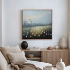 A cozy, neutral-toned living room features a light sofa, beige cushions, wooden sideboard, decorative vases, and the Dawn Meadow Canvas Art - Square above the sideboard, adding tranquil charm with its misty wildflower meadow scene.