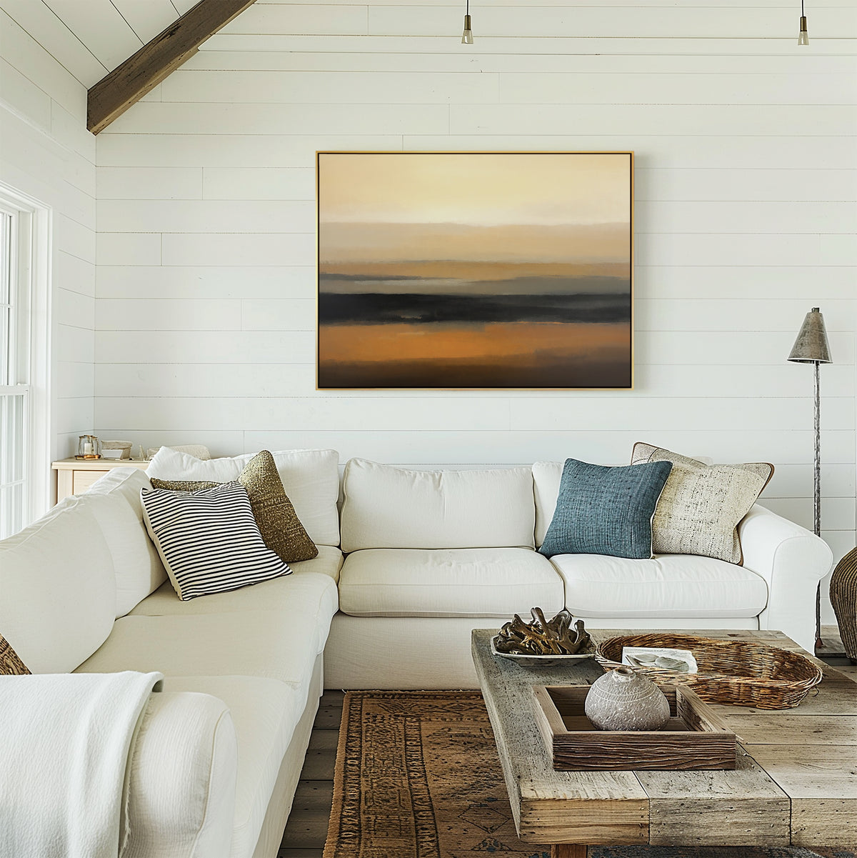 Bright, cozy living room with a white sectional sofa, assorted pillows, rustic wooden coffee table, woven baskets, and the Desert Mirage Canvas Art - Horizontal in earth tones hanging on a white shiplap wall.