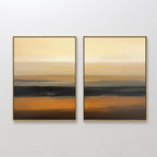 Desert Mirage - Set Of 2 features framed abstract prints with horizontal layers of gold, orange, brown, and black. The earthy tones blend seamlessly to create a serene gradient effect inspired by desert landscapes.