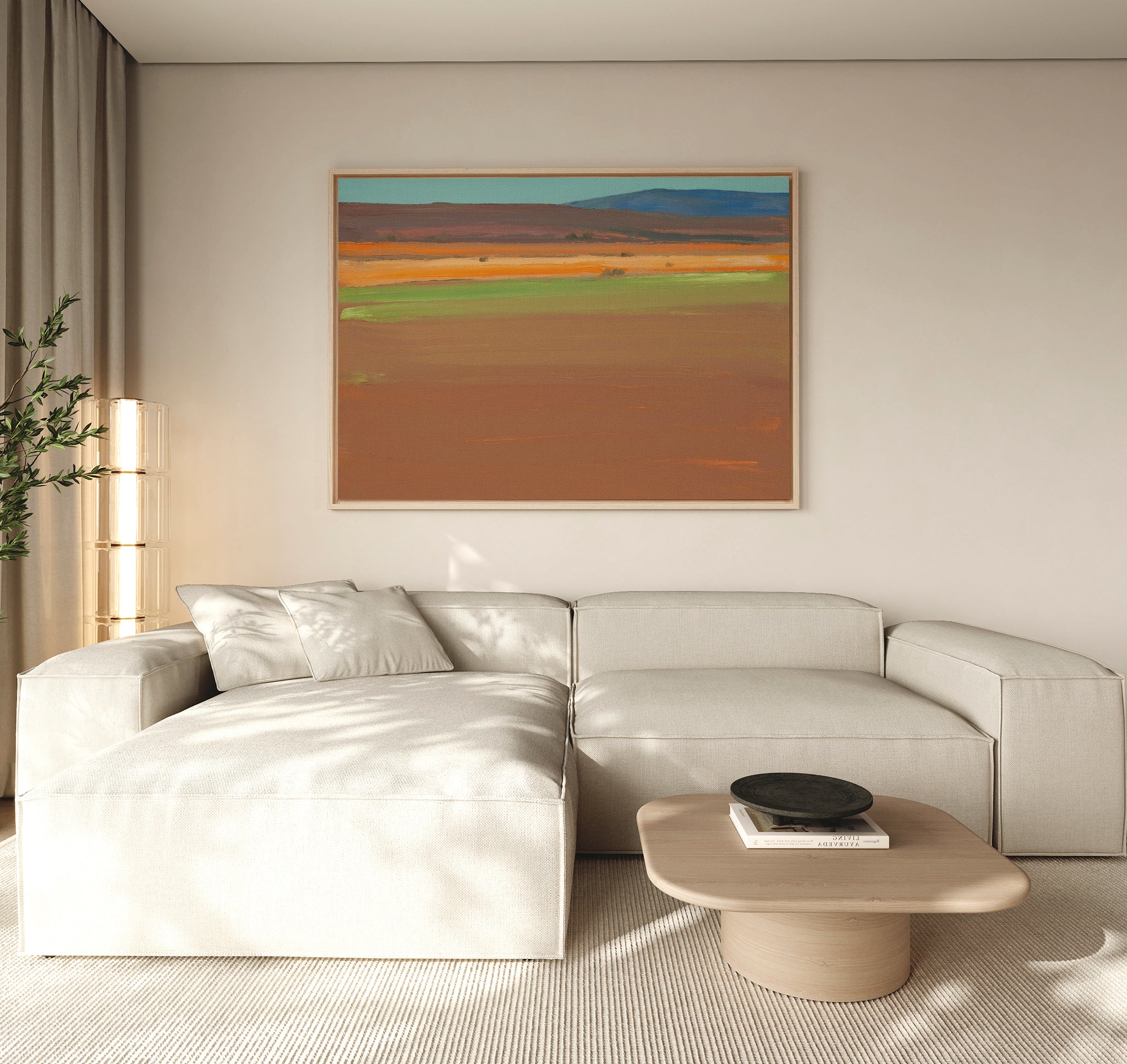 A modern living room with a light beige sectional, low wood coffee table, tall plant, floor-to-ceiling curtains, and the Desert Plains Canvas Art - Horizontal brings southwestern warmth to the space.