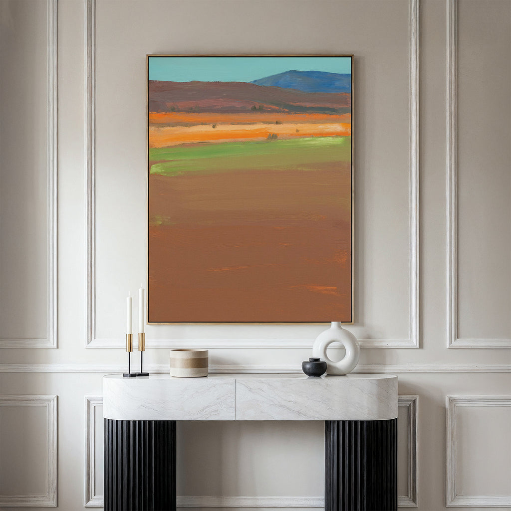 A modern console table with decor stands against a paneled wall, topped by the Desert Plains Canvas Art - Vertical—an abstract landscape in earthy tones, ideal for enhancing modern living room decor.