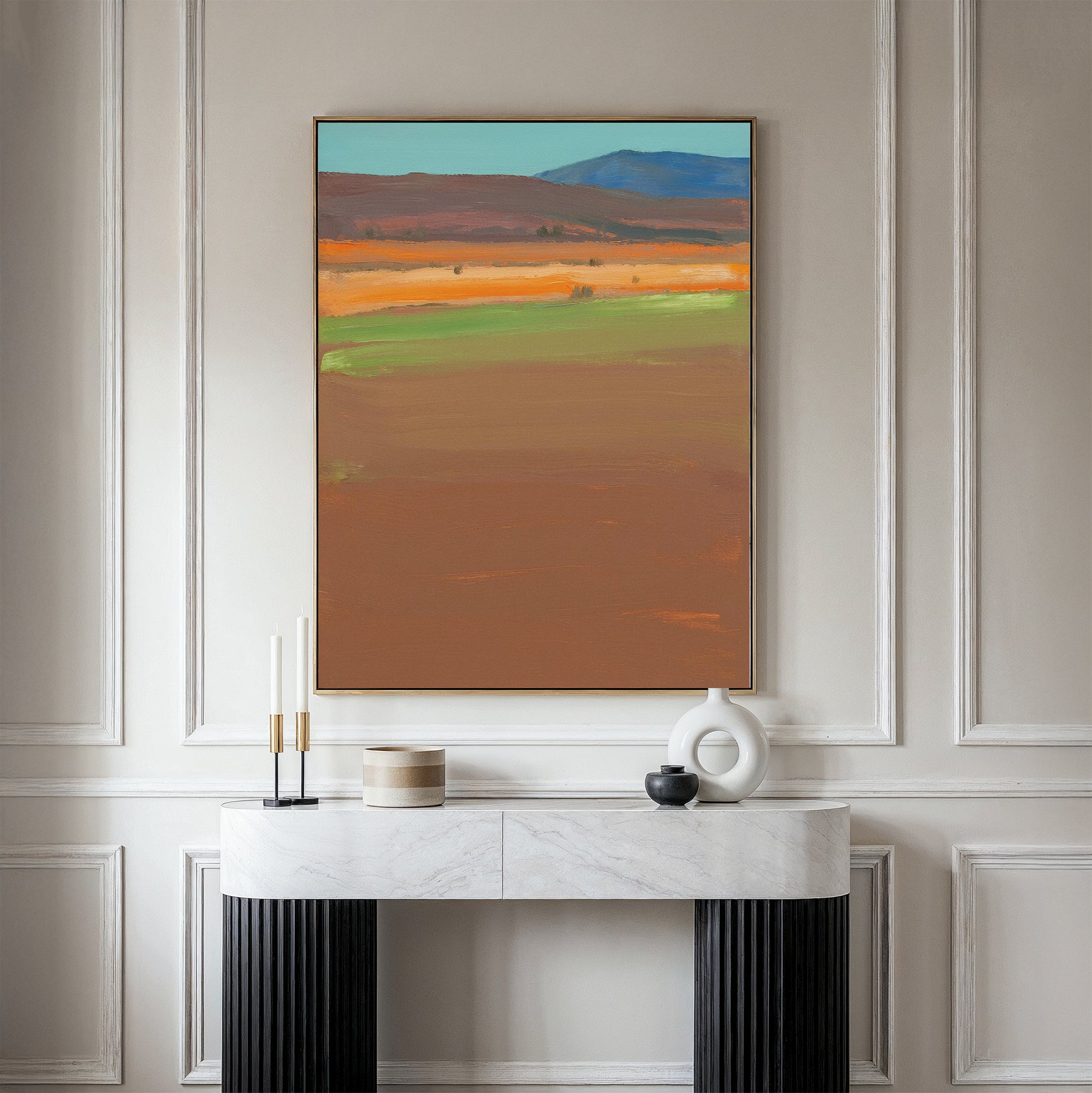 A modern console table with decor stands against a paneled wall, topped by the Desert Plains Canvas Art - Vertical—an abstract landscape in earthy tones, ideal for enhancing modern living room decor.
