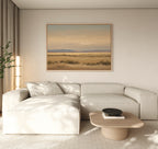 A modern living room features a light beige sectional sofa, wooden coffee table, potted plant, and the Desert Solitude Canvas Art - Horizontal above the sofa. The space is bright and minimalistic with serene wall decor.