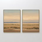 The "Desert Solitude - Set of 2" showcases two framed artworks side by side on a white wall, featuring serene southwestern landscapes with dry grass, low shrubs, distant blue mountains, and a soft pastel sky.
