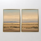 Desert Solitude - Set of 2 features southwestern landscape art with dry grass, distant hills, and a cloudy sky in earth tones, creating serene wall decor on a plain white wall.
